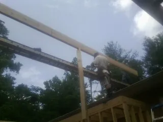 Carpenter setting a ridge beam over a new addition frame — Ice Dam Removal by Roofing Brothers in Averill Park