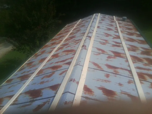Rusted metal roof panels with new wood purlins before replacement — Storm Damage Roof Repair in Averill Park by Roofing Brothers