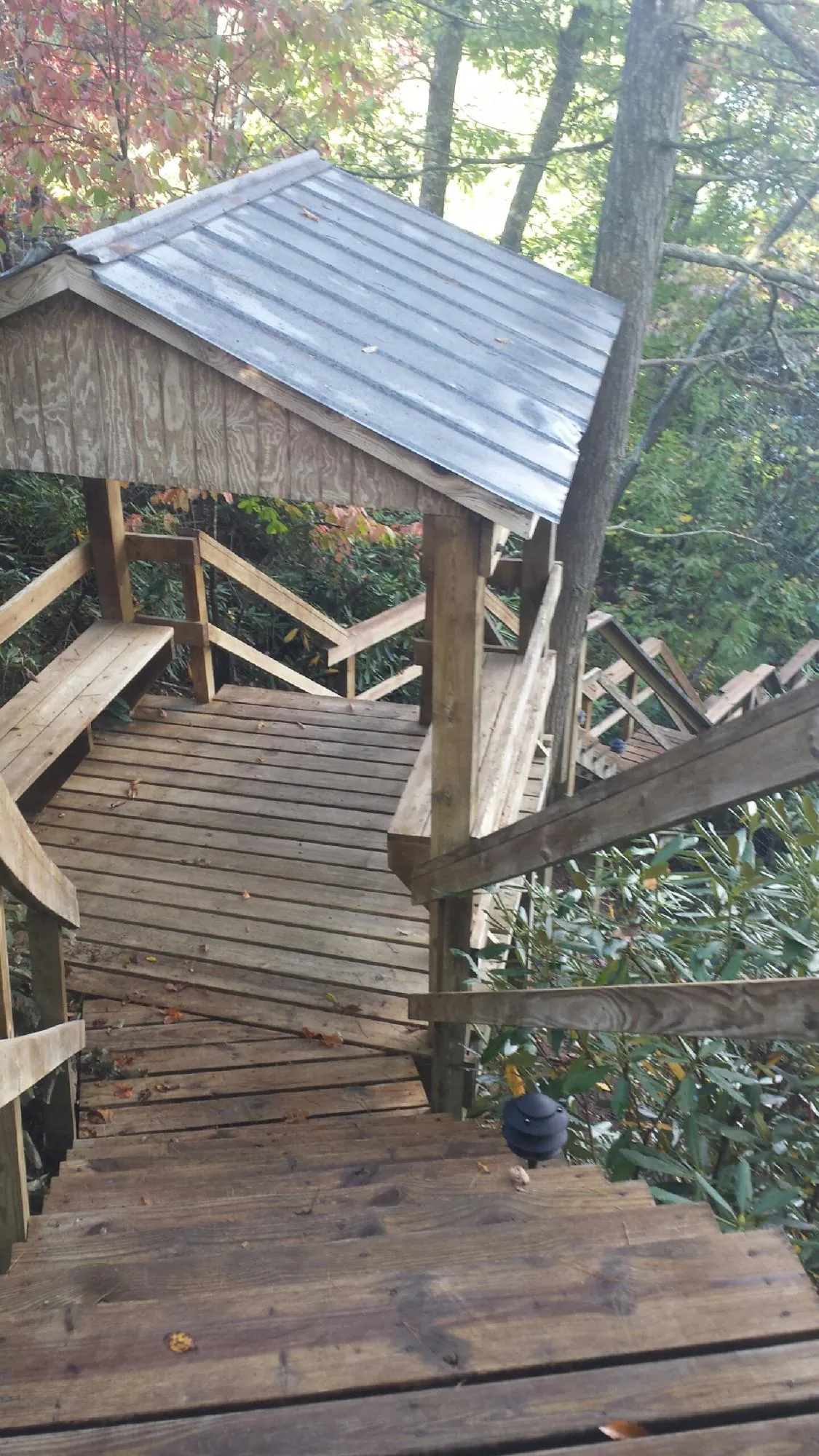 Metal roofed shelter over wooden steps on a wooded walkway — Skylight Repair & Installation work by our crew in Averill Park