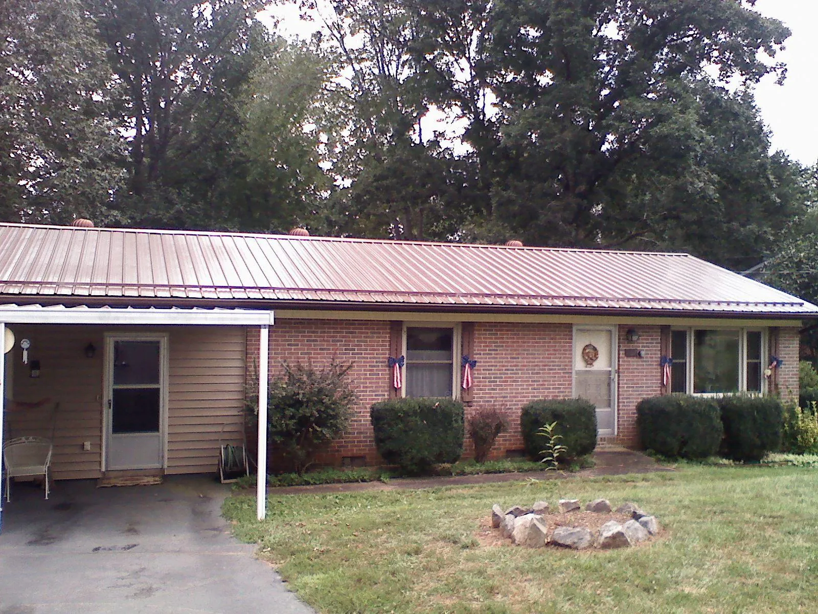 Bronze metal roof and carport on a brick ranch home — Roof Repair work by our crew in Averill Park